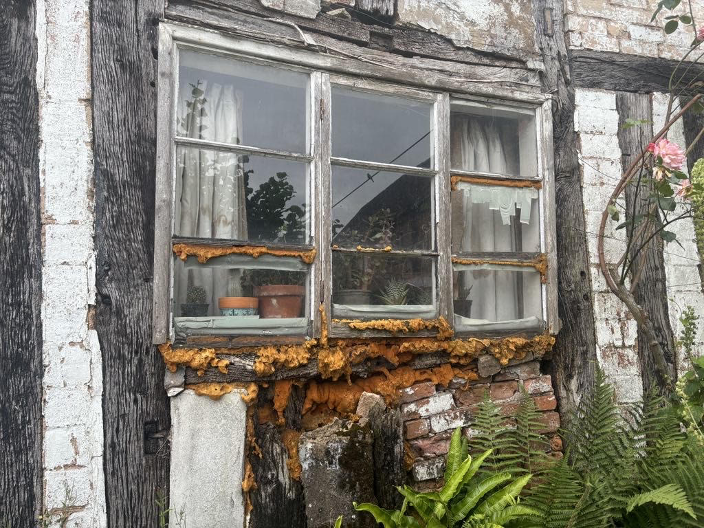 Traditional timber-framed property with deteriorating window before restoration by O.F Carpentry and Building
